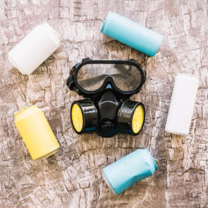 Close-up of a gas mask surrounded by colorful tin cans.