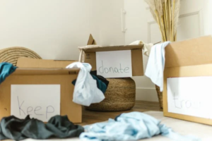 Cardboard boxes labeled for donation, keeping, and junk removal during a home decluttering process