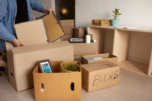 Man packing labeled boxes while preparing to move out of his home