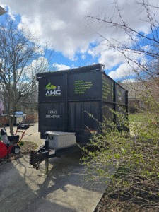 An AMG Junk Removal dumpster rental is ready for loading outside a residential home