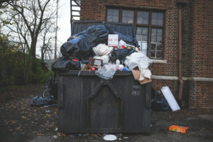 Overflowing dumpster outside brick building in Cleveland